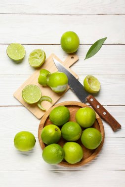 Beyaz ahşap arka planda taze limonlu levha ve kesim tahtası.