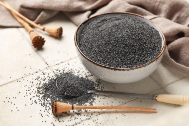 Beyaz fayanslı haşhaş tohumlu kase ve kaşık, yakın plan.