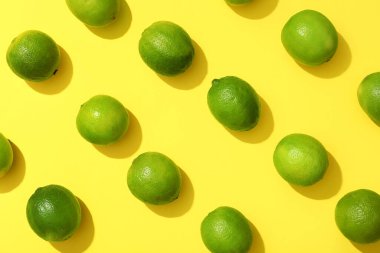 Sarı arka planda bir sürü taze limon