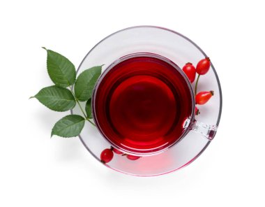 Beyaz arka planda bir bardak sıcak gül çayı ve böğürtlen.