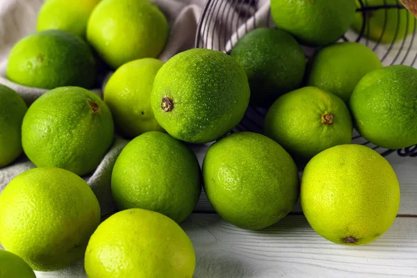 Beyaz ahşap arka planda taze limonlar, yakın plan.