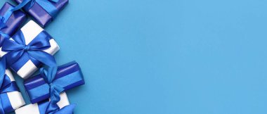 Mavi arka planda Noel hediyesi kutuları olan şenlikli kompozisyon