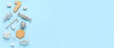 Açık mavi arkaplan üzerine çerez ve Noel süslemeleri ile kompozisyon metin için boşluk