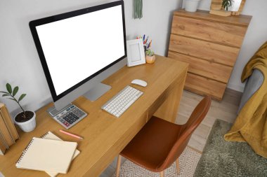 Boş bilgisayar monitörlü işyeri odada ışık duvarının yanında.