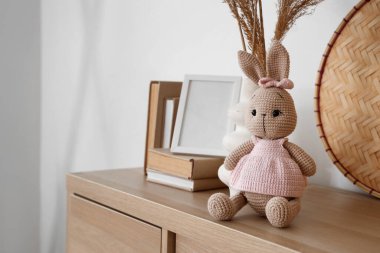 Çimenli vazolar, oyuncak tavşanlar ve çocuk odasındaki çekmecelerle ilgili kitaplar, yakın plan.