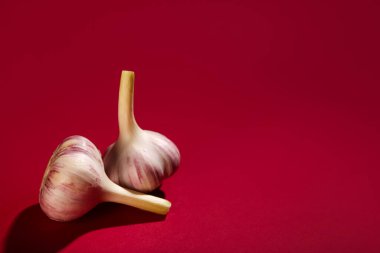 Kırmızı arka planda taze sarımsak.