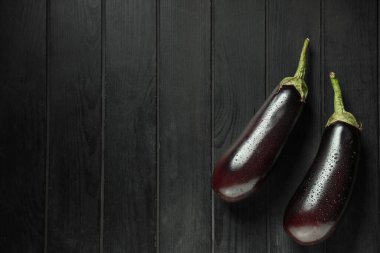 Koyu ahşap arka planda taze patlıcanlar