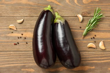 Sarımsaklı taze patlıcan, biberiye ve ahşap zemin üzerinde biber.