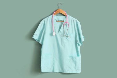 Steteskop ve turkuaz arka planda tıbbi üniforma.