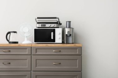 Beyaz duvara karşı farklı modern ev aletleri.