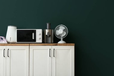 Yeşil duvara karşı modern ev aletleri dizisi