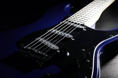 Siyah ahşap arka planda modern elektro gitar, yakın plan