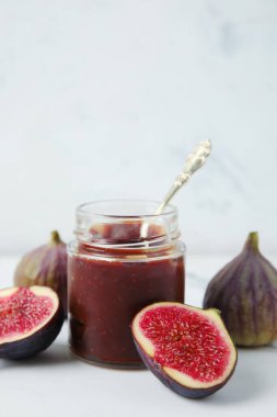 Kavanoz dolusu incir reçeli ve mermer kaplama kaşık.