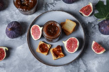 Gri grunge arka planda tatlı incir reçeli tabağı ve lezzetli tostlar.