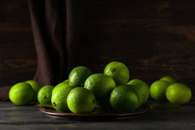 Siyah ahşap masadaki taze limonlu tabak.