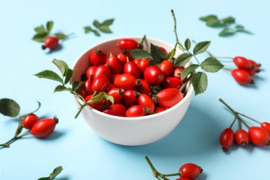 Mavi arka planda taze böğürtlen ve yapraklı kase