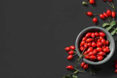 Siyah arka planda taze gül böğürtlenli kase