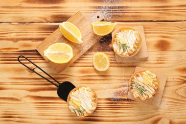 Ahşap arka planda lezzetli limonlu tartlar.