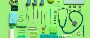 Yeşil arka planda steteskop ve şırıngayla tıbbi malzemeler. Üst görünüm