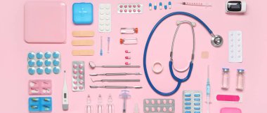 Steteskoplu tıbbi malzemeler, termometre ve pembe arka planda haplar. Üst görünüm