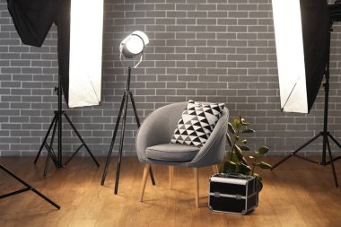 Profesyonel ekipman ve koltuk ile aydınlatılmış fotoğraf stüdyosunun içi