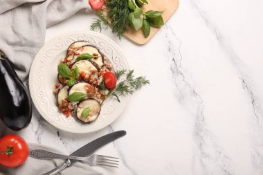 Fırında patlıcan dilimleri, domates, dereotu ve fesleğen yapraklı mermer zemin