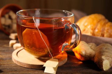 Ahşap zemin üzerinde zencefil olan bir fincan sıcak çay.