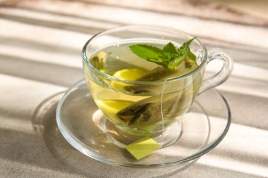 Hafif arkaplanda nane yapraklı bir fincan sıcak çay