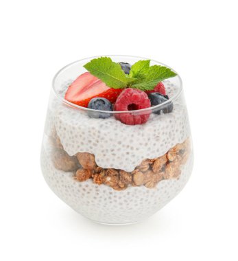 Bir bardak nane yapraklı chia tohumu pudingi, granola ve böğürtlen beyaz arka planda.