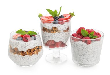 Bardaklar dolusu nane yapraklı chia tohumu pudingi, granola ve böğürtlen beyaz arka planda.