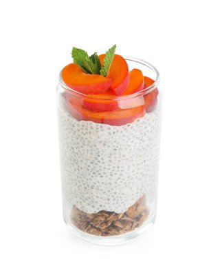 Bir bardak nane yapraklı Chia tohumu pudingi, granola ve beyaz arka planda kayısı dilimleri.