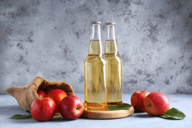 Gri grunge arka planda taze meyve ve elma şırası dolu çuval.