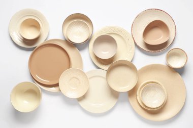 Beyaz arkaplanda bej plakalar ve kaseler