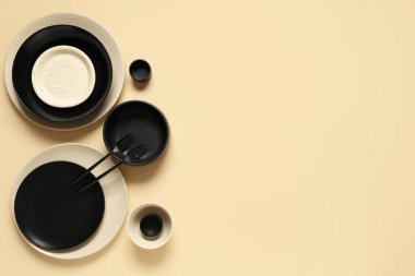 Bej arka planda seramik tabaklar, kaseler ve çatallar