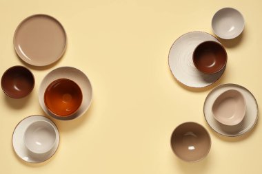 Bej arka planda temiz tabak ve kaselerden yapılmış çerçeve