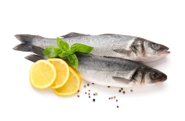 Siyah biberli taze deniz kabuğu balığı, fesleğen yaprağı ve beyaz arka planda izole edilmiş limon dilimleri, yakın plan.