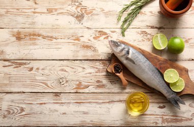 Taze çiğ deniz kabuğu balığı ve beyaz ahşap arka planda farklı baharatlarla kesilmiş tahta.