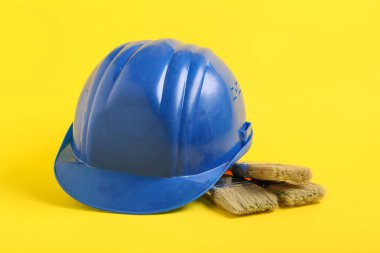 Sarı arka planda fırçalı mavi şapka