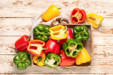 Beyaz ahşap arka planda taze dolma biberli hasır tepsi.