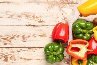 Beyaz ahşap arka planda taze dolma biberli hasır tepsi.