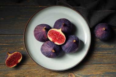 Siyah ahşap arka planda taze incir tabağı, yakın plan.