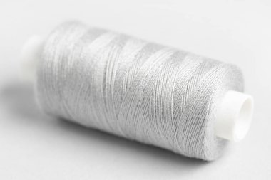 Gri arkaplanda iplik makarası, yakın plan