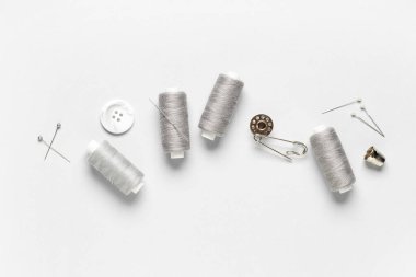 Gri arkaplanda iplik ve dikiş malzemeleri