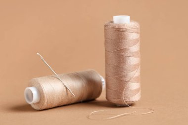 Kahverengi zemin üzerinde iğne olan iplik makaraları