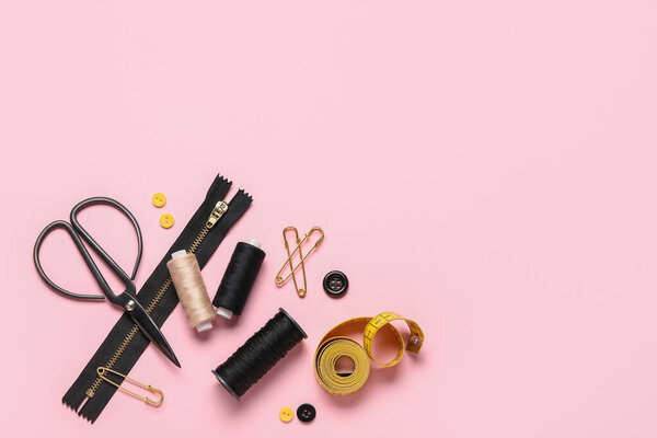 Состав с нитками, ножницами и кнопками на розовом фоне