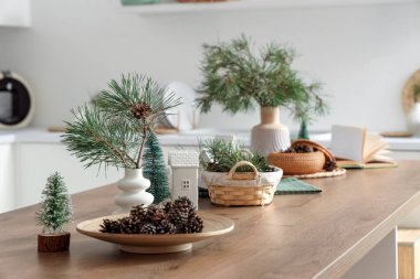 Mutfaktaki kozalaklı tepsi ve Noel dekoru.