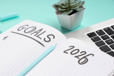 2026 gollü ve yeşil arkaplanda dizüstü bilgisayarı olan defter, yakın plan