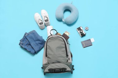 Seyahat eşyaları, elbiseler ve ayakkabılar mavi arka planda.