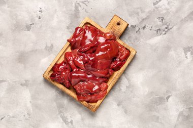 Gri grunge arka planda çiğ karaciğer olan tahta tahta tahta.