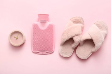 Pembe arka planda terlikler ve sıcak su torbası.